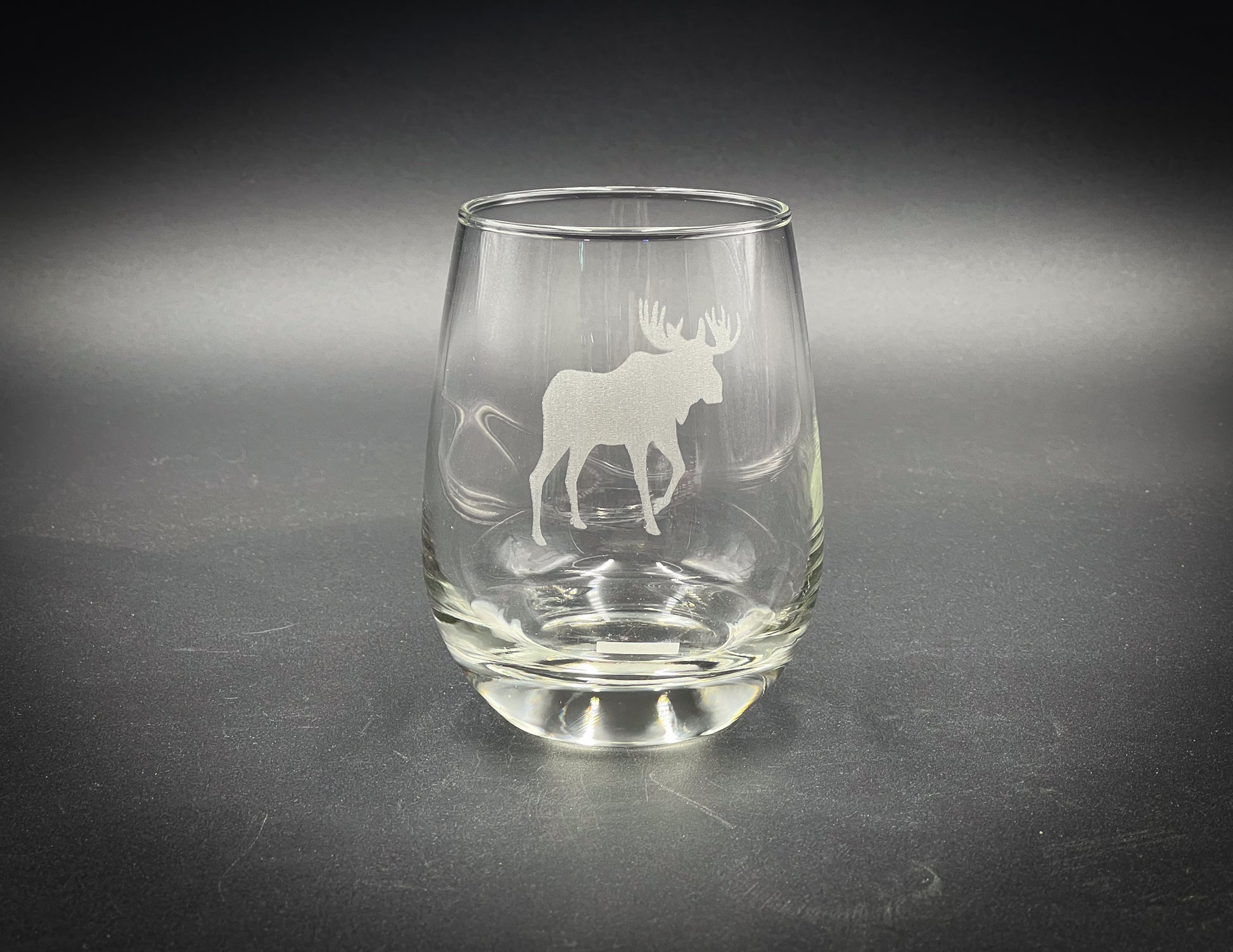 a glass with a moose on it sitting on a table