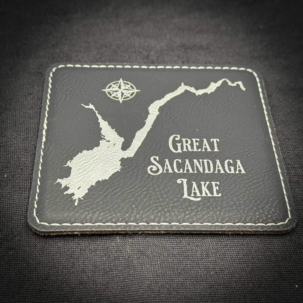 A cork coaster with the word "GOTHICS" printed on it, featuring a variety of words arranged in a circular pattern.