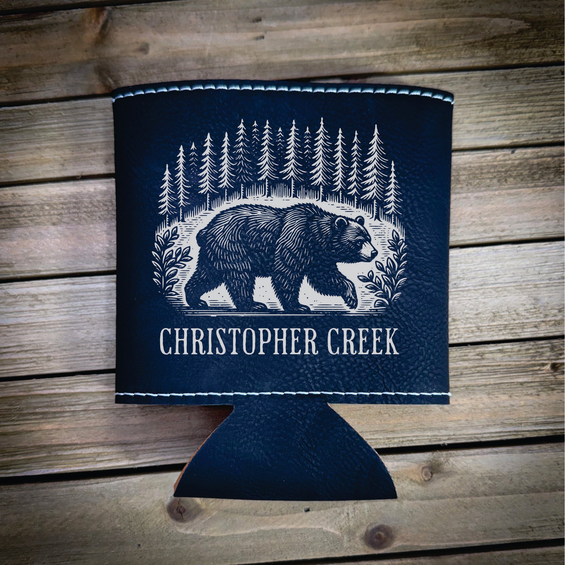 A blue cooler with a bear illustration and the text "CHRISTOPHER CREEK" printed on it, placed on a wooden surface.