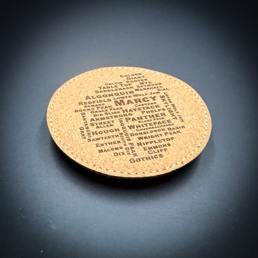 A cork coaster with the word "GOTHICS" printed on it, featuring a variety of words arranged in a circular pattern.