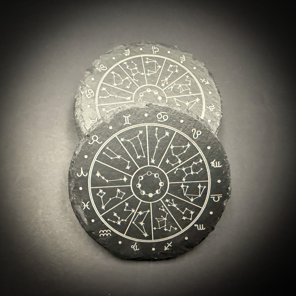 two circular coasters with astrological symbols and zodiac signs printed on them.