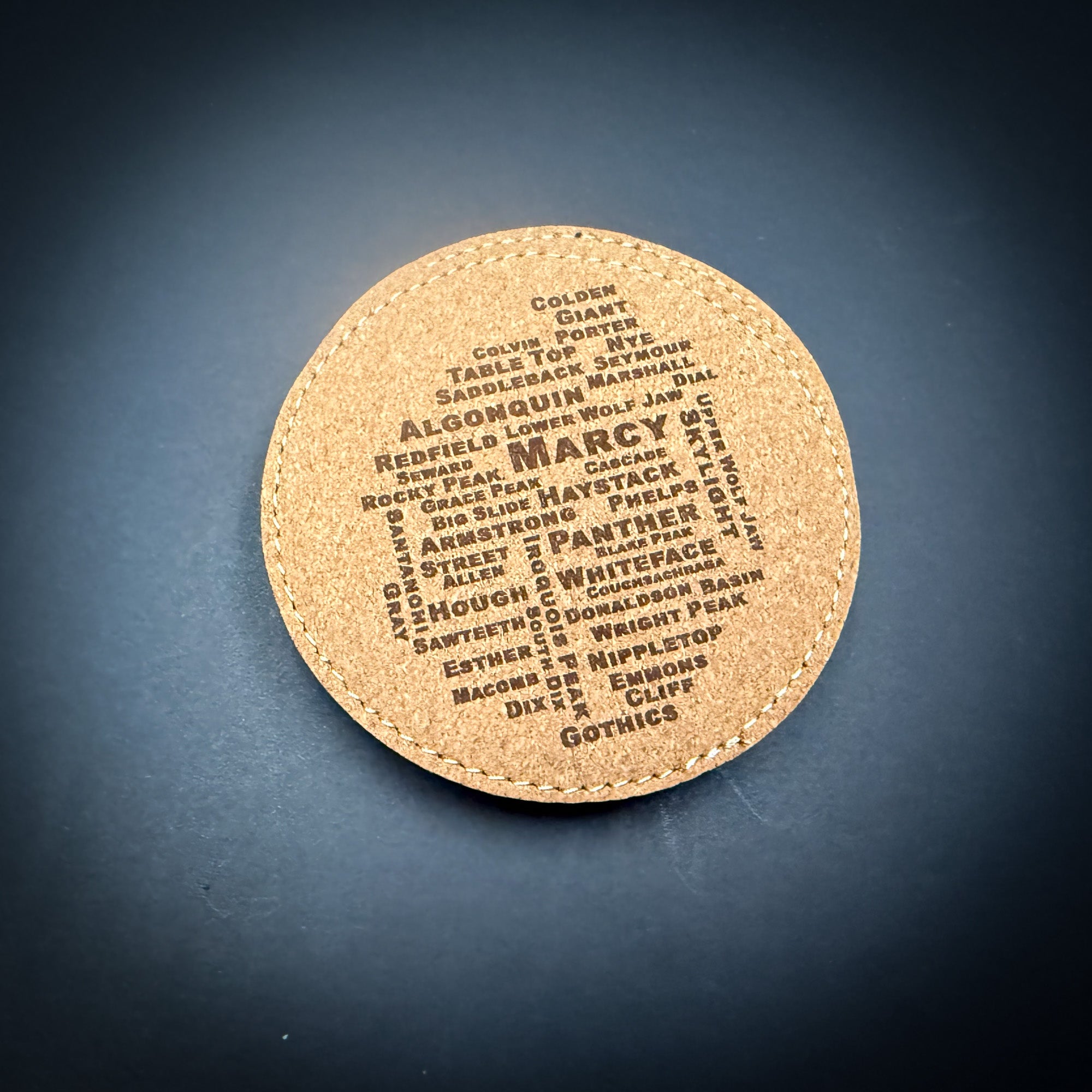 a circular coaster with the word "MARCY" printed on it in a large font.