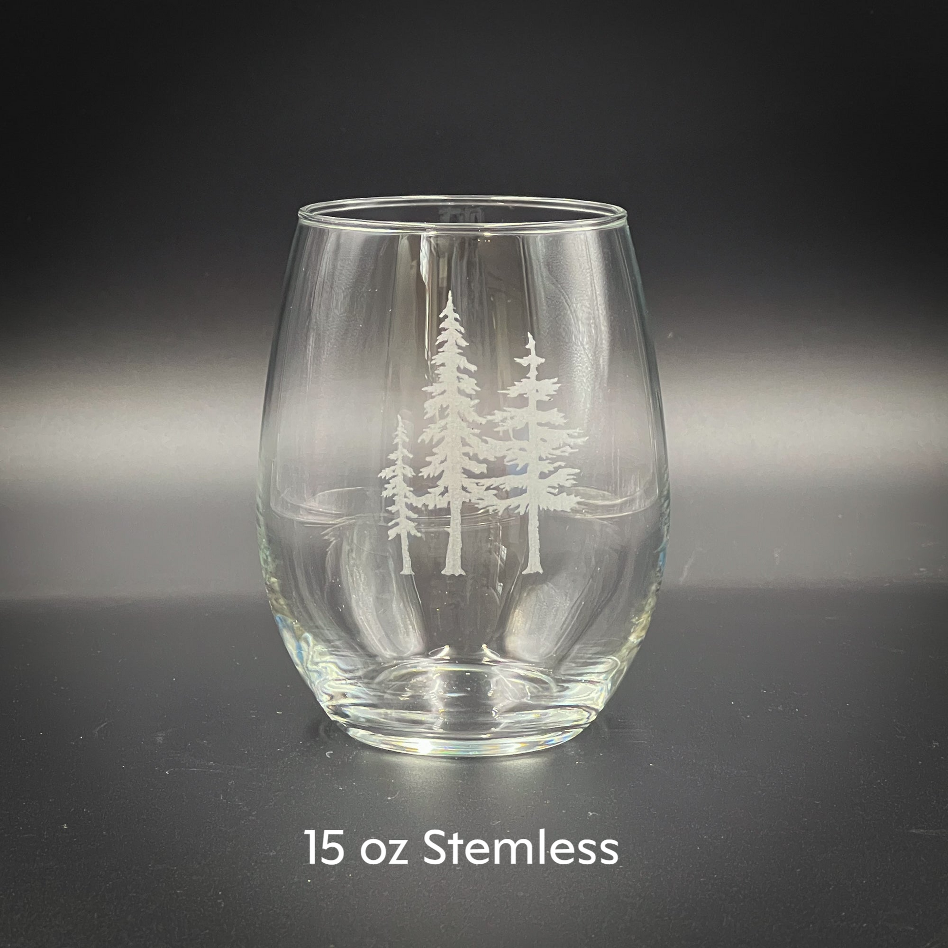 a clear glass with a white tree etched on it