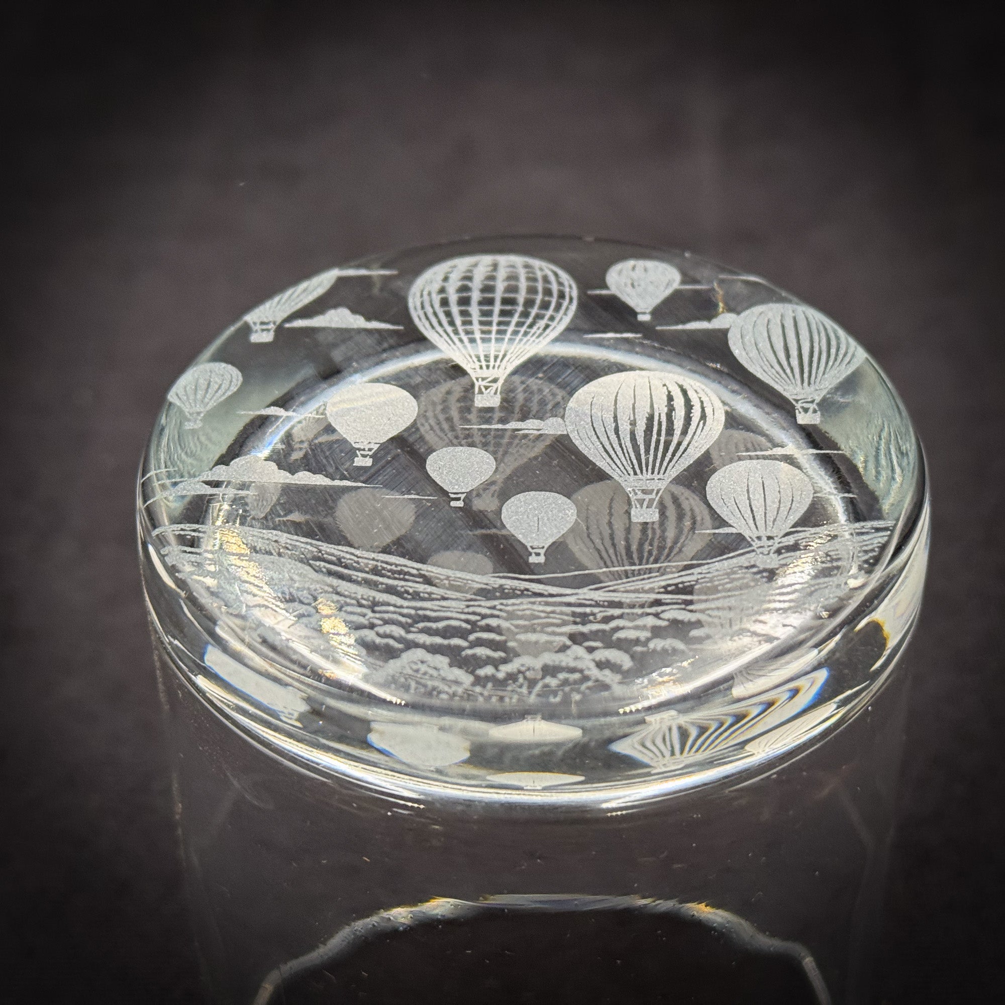 A glass jar with a lid featuring a design of hot air balloons floating in the sky.