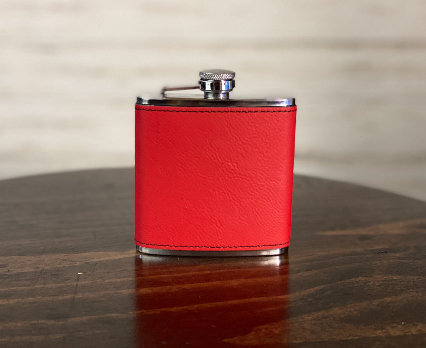 a red leather flask on a wooden table