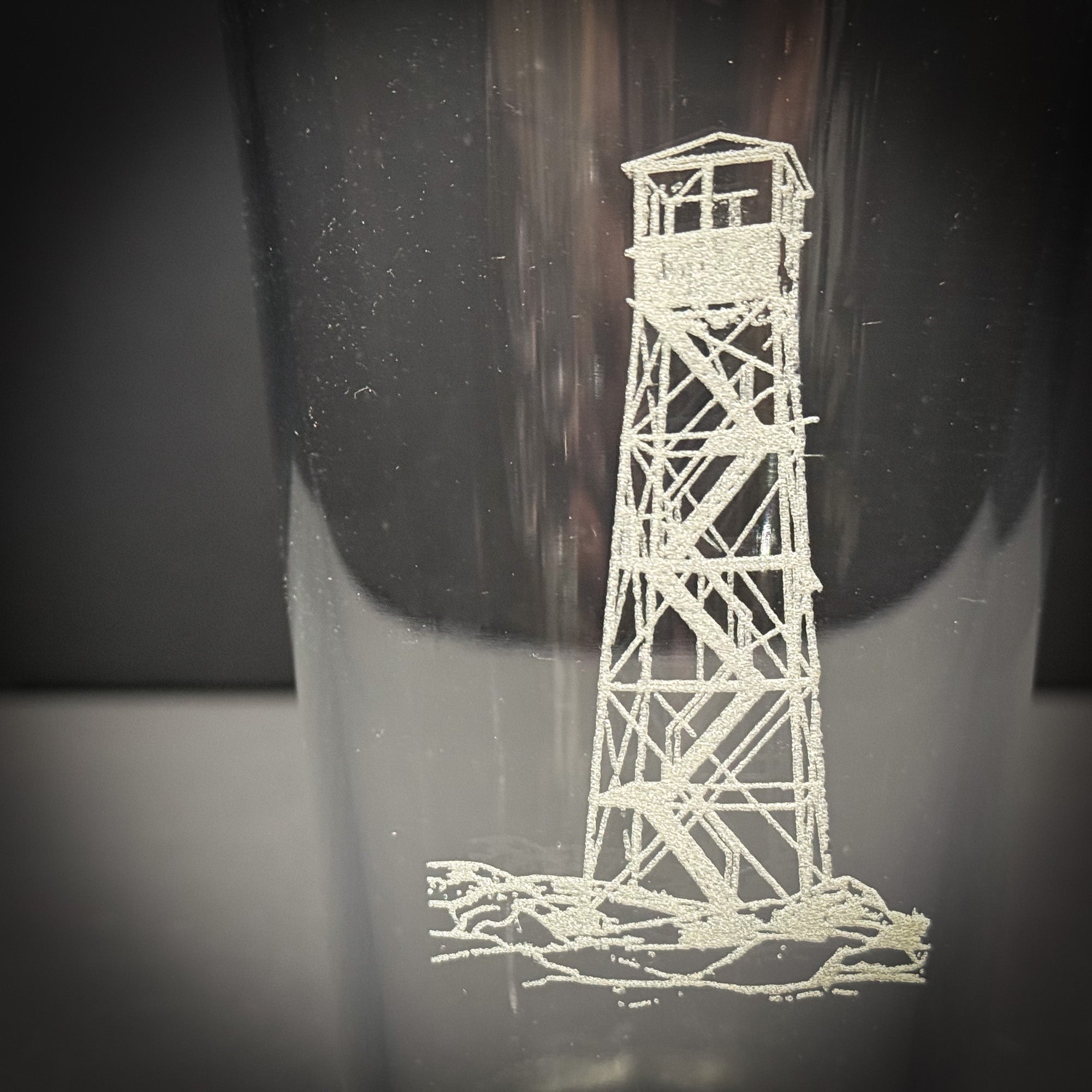a tall, white lighthouse with a pointed roof and a small tower at the top, standing on a rocky shore.