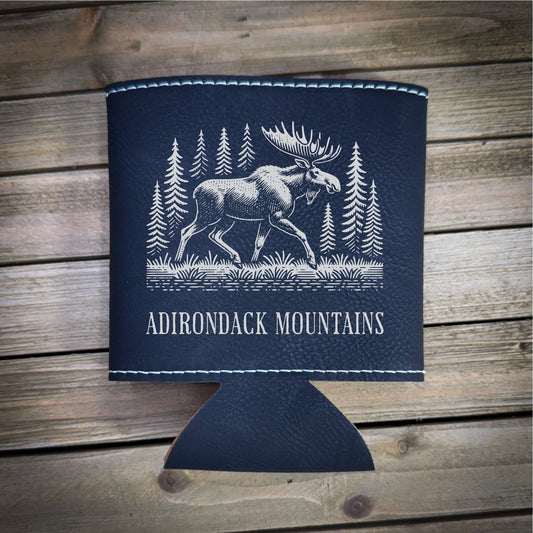 A black leather cooler with a white illustration of a moose and pine trees, along with the text "ADIRONDACK MOUNTAINS" printed on it.