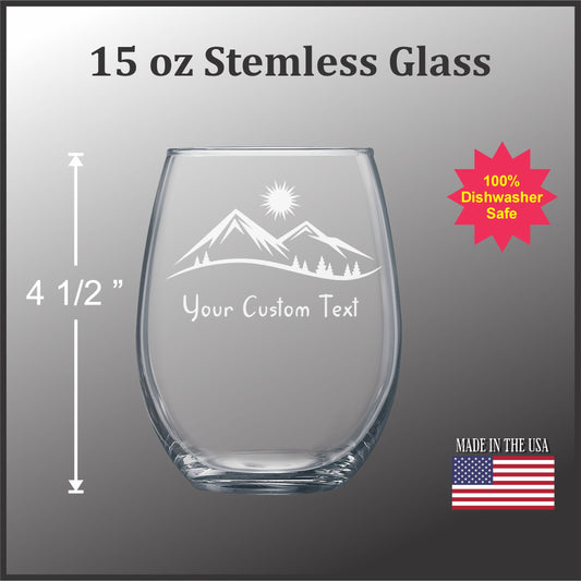 a stemless glass with a mountain landscape etched onto it. The glass is described as 15 oz and is labeled as a "Stemless Glass" with a "Your Custom Text" feature. The glass is also described as "Made in the USA" and has a "100% Dishwasher Safe" sticker.