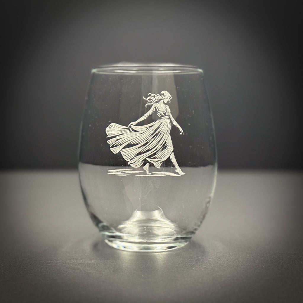 A glass with a white engraved image of a woman in a flowing dress.