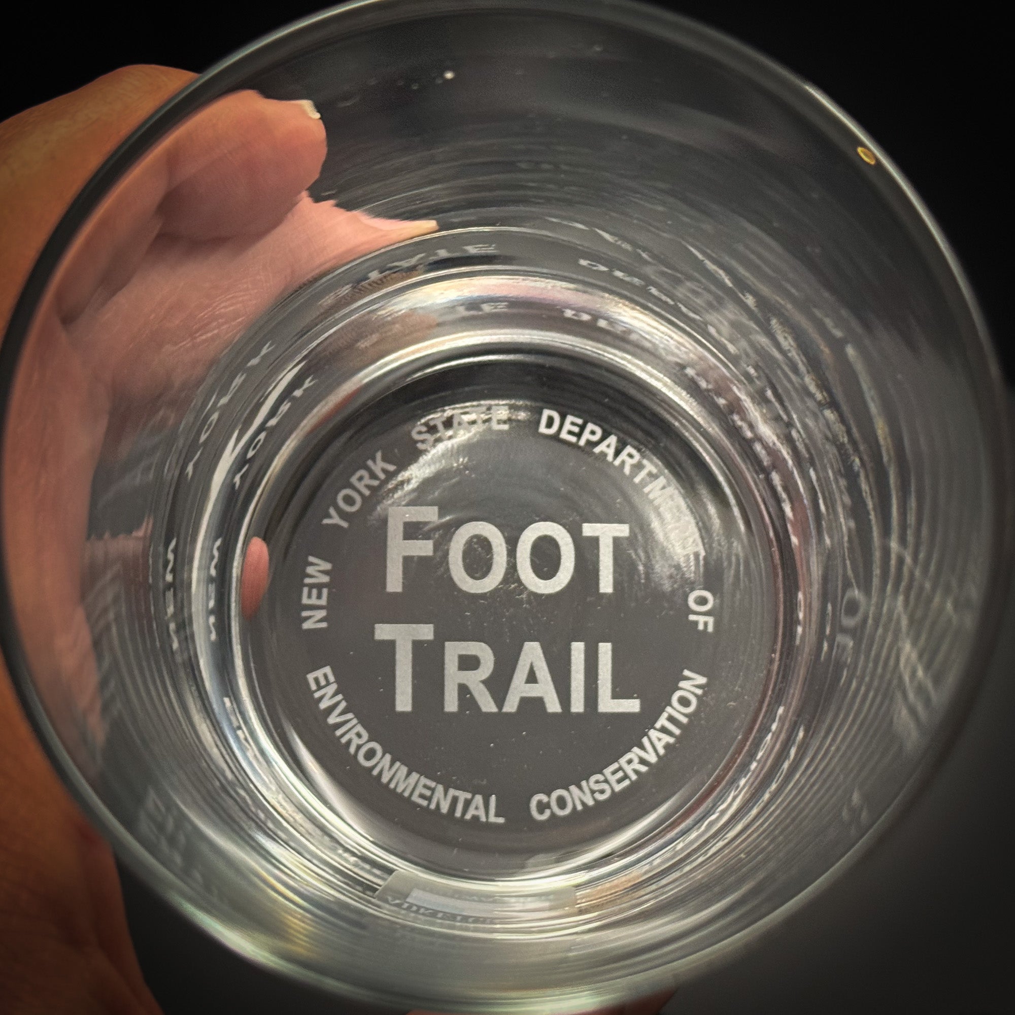 A glass with the text "FOOT TRAIL" printed on it, indicating it is a glass used for the New York State Department of Environmental Conservation's "Foot Trail" program.