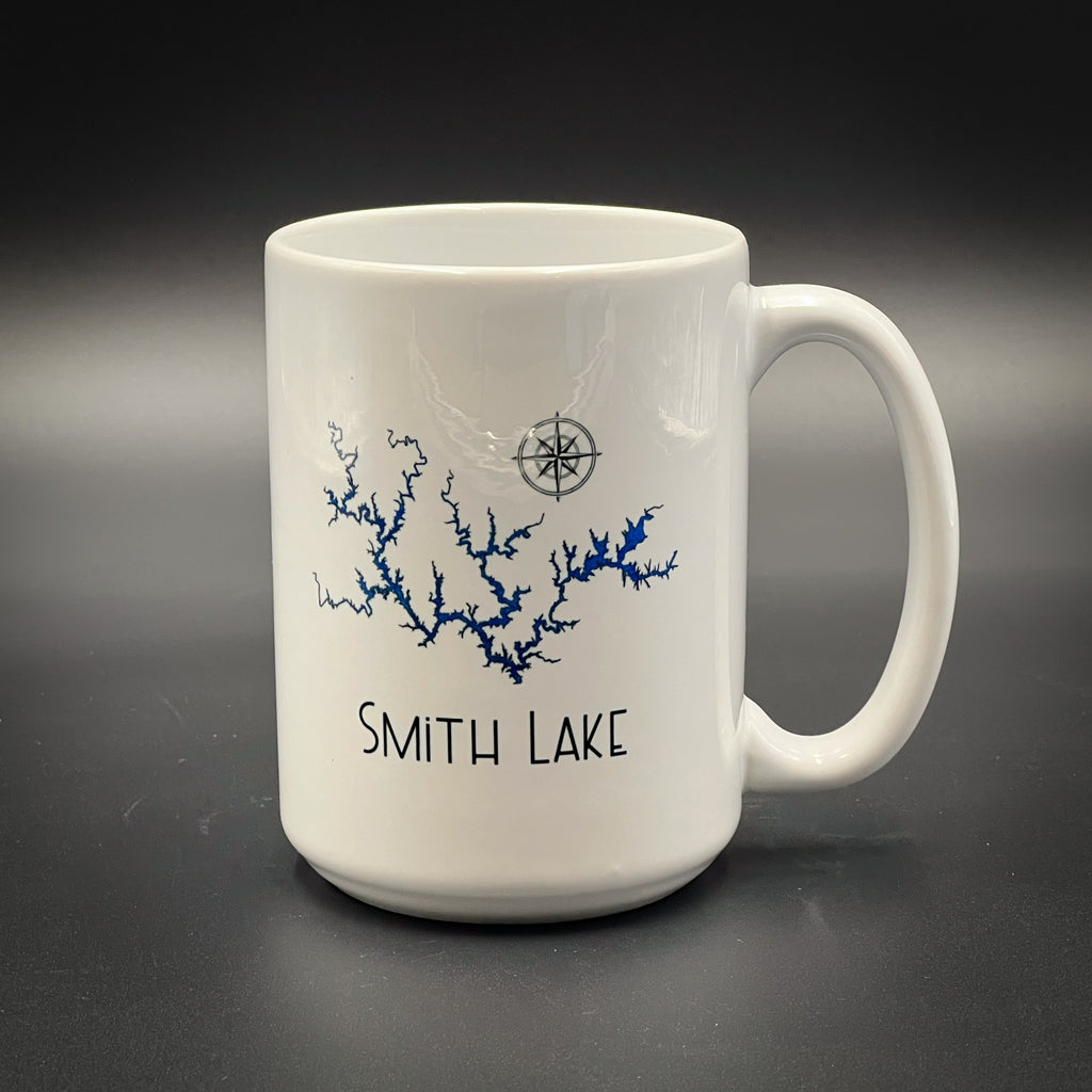 A white ceramic mug with a blue design depicting a river or lake, along with the text "SMITH LAKE" printed on it.