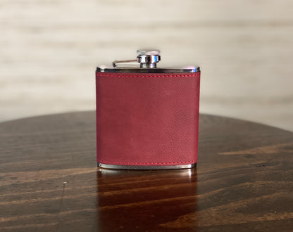 a red leather flask on a wooden table