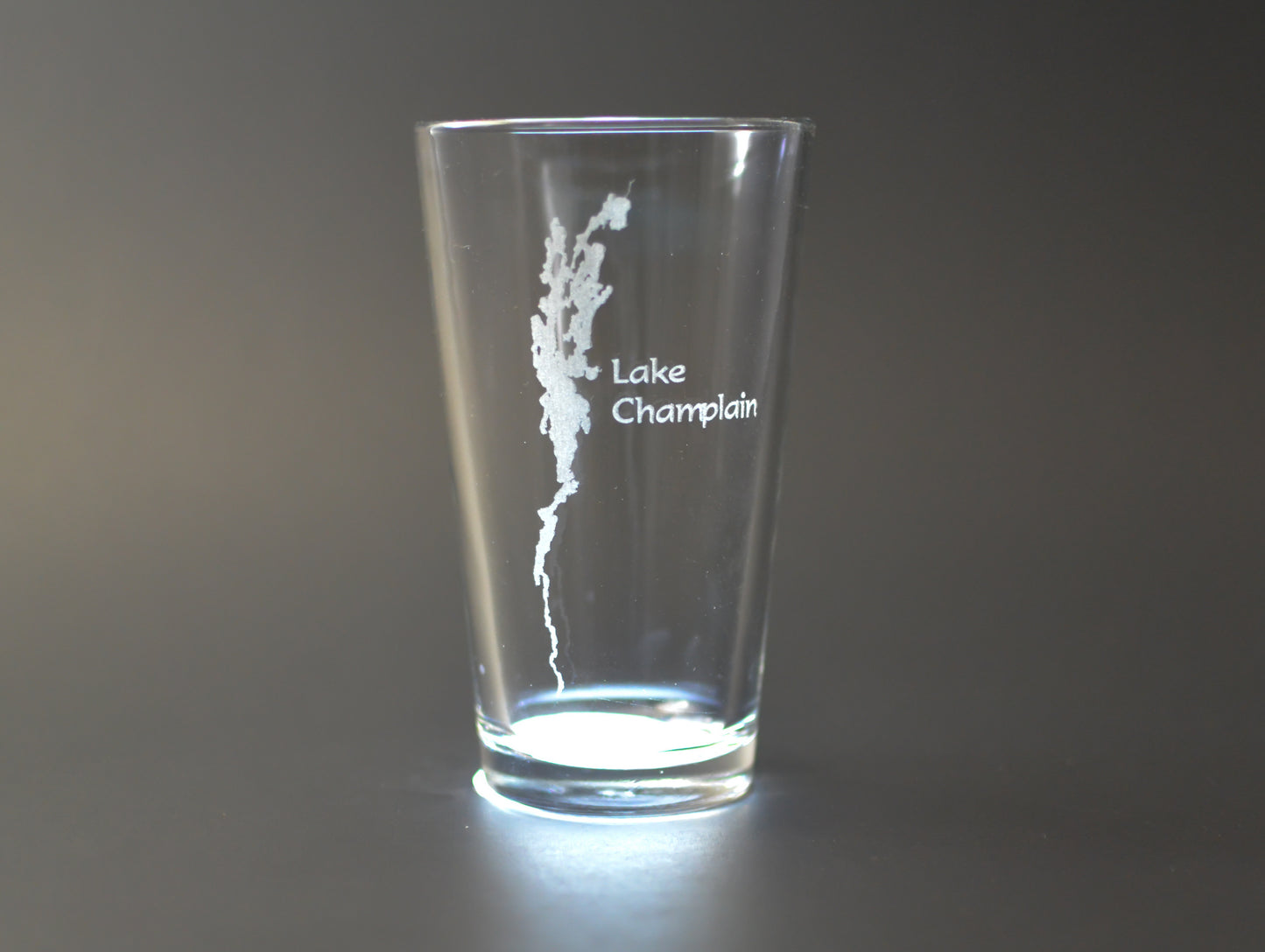 a shot glass with a lake champal etched on it