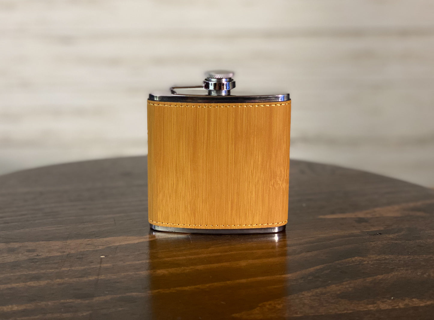 a wooden table with a metal flask on it
