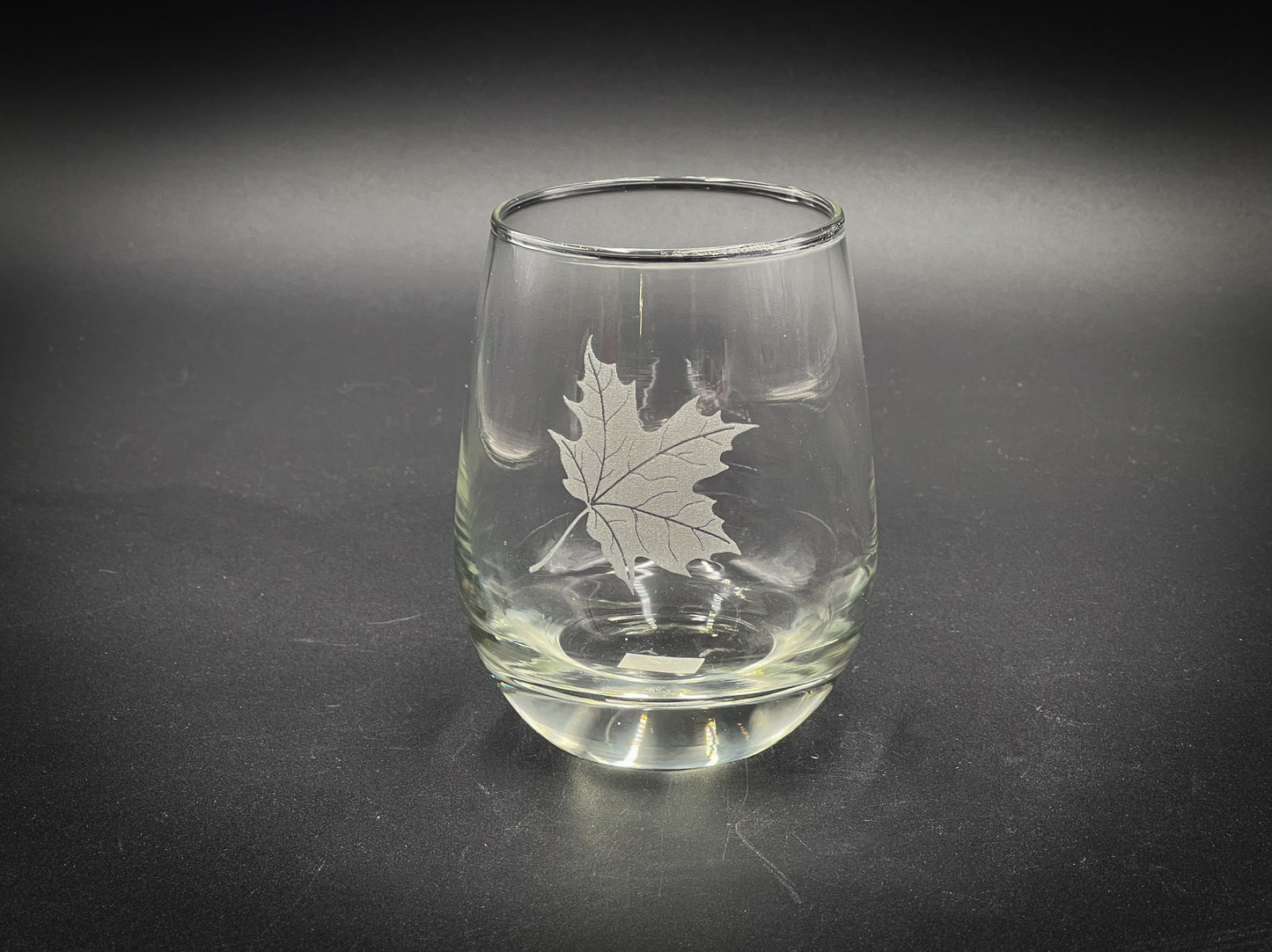 a glass with a maple leaf etched on it