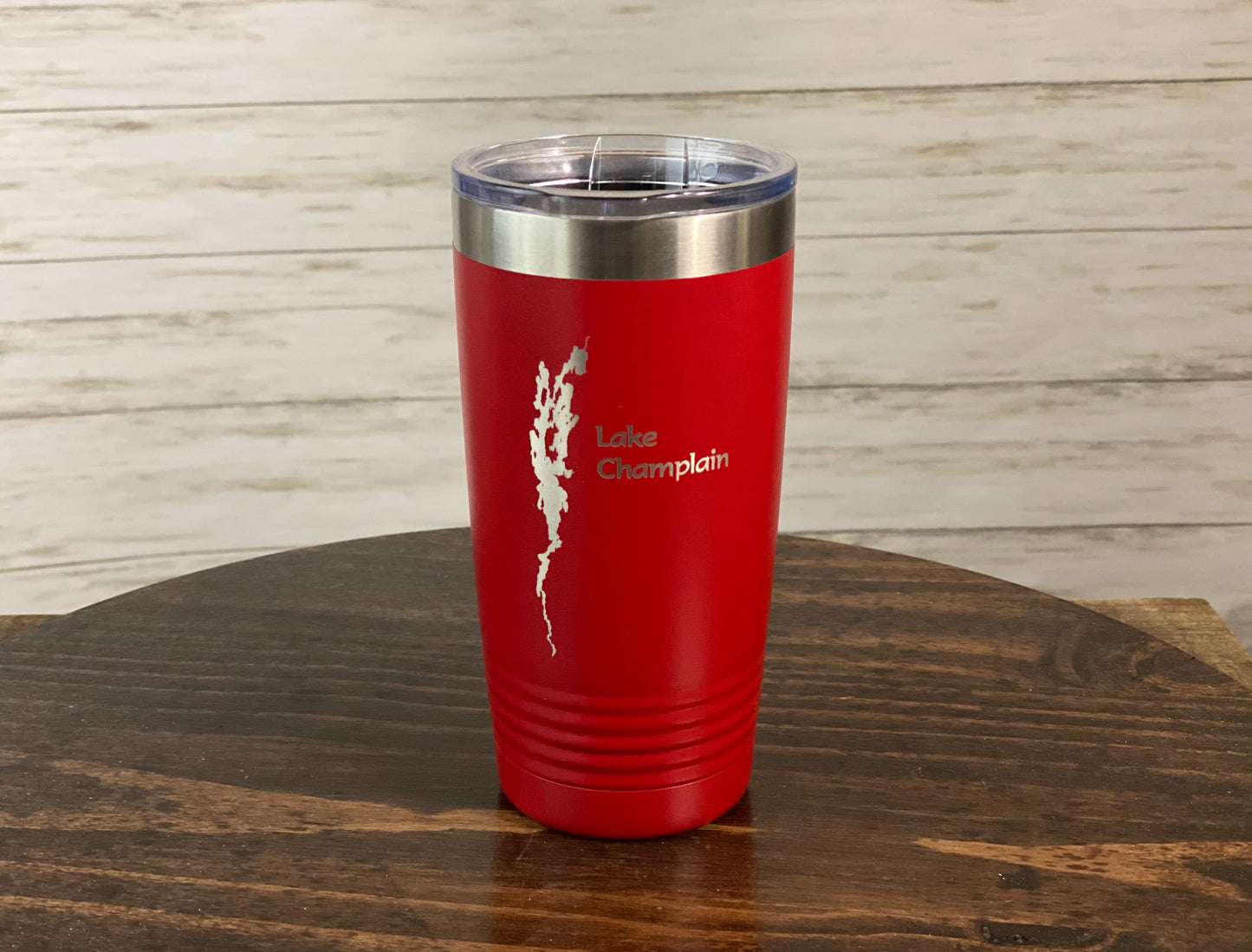a red tumbler sitting on top of a wooden table