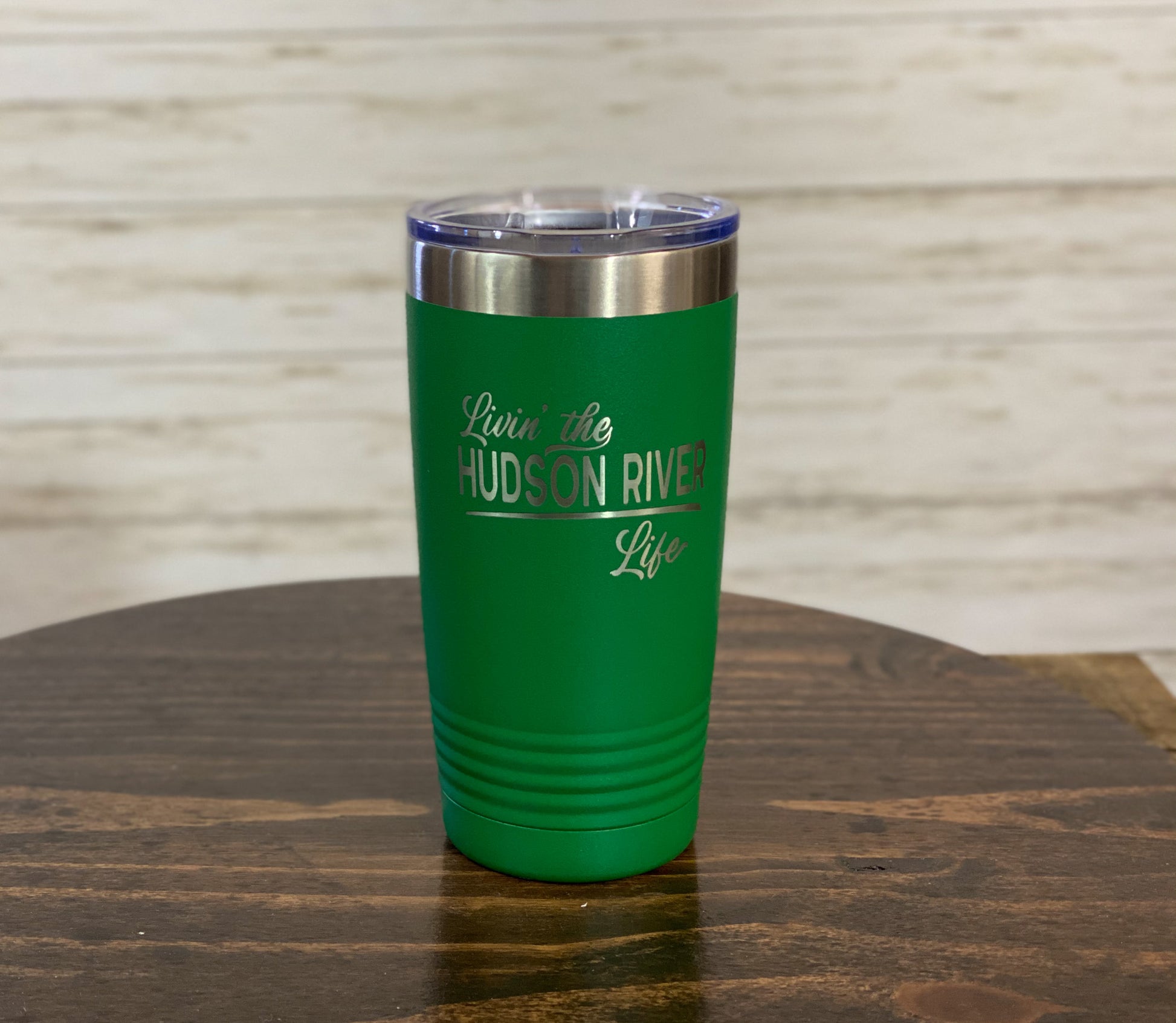 a green tumbler sitting on top of a wooden table