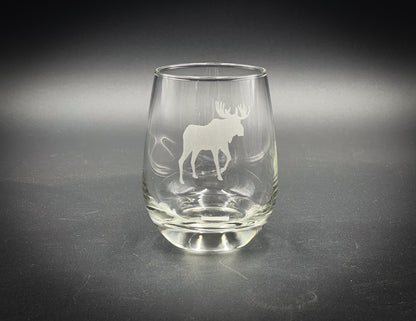 a glass with a moose on it sitting on a table