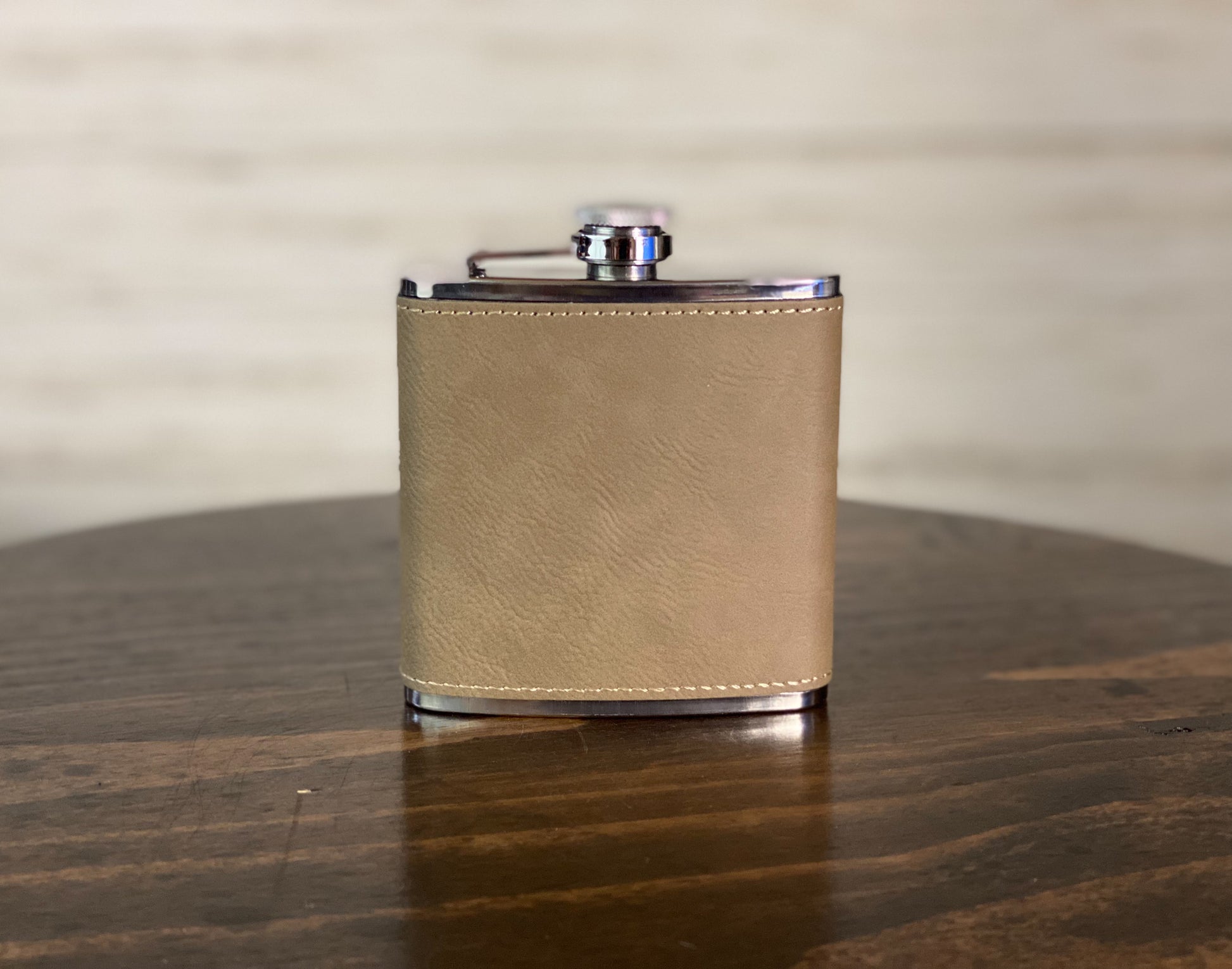 a tan leather flask on a wooden table